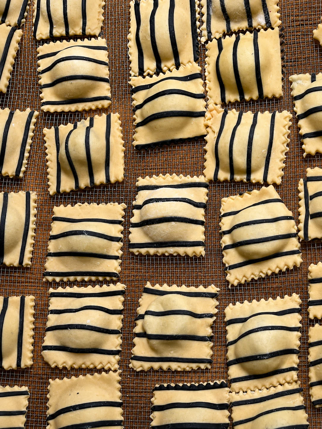 Striped handmade ravioli with black pasta decoration